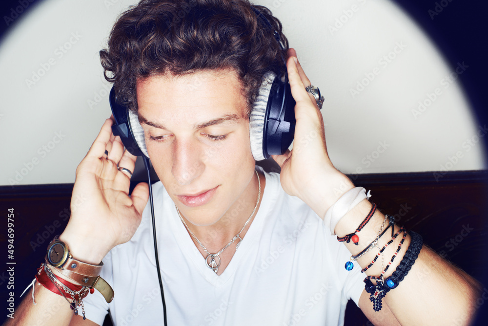 Rocking to the beat. Close up shot of a young man grooving to some music on a set of headphones surr