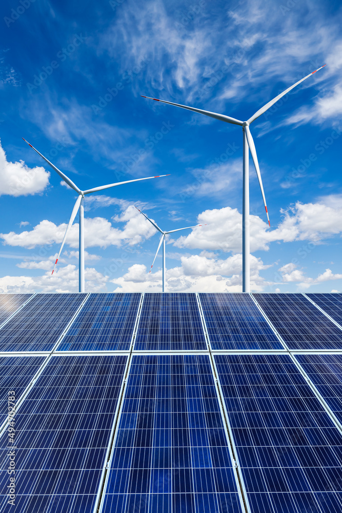 蓝天下的太阳能电池板和风力涡轮机景观。绿色能源概念。