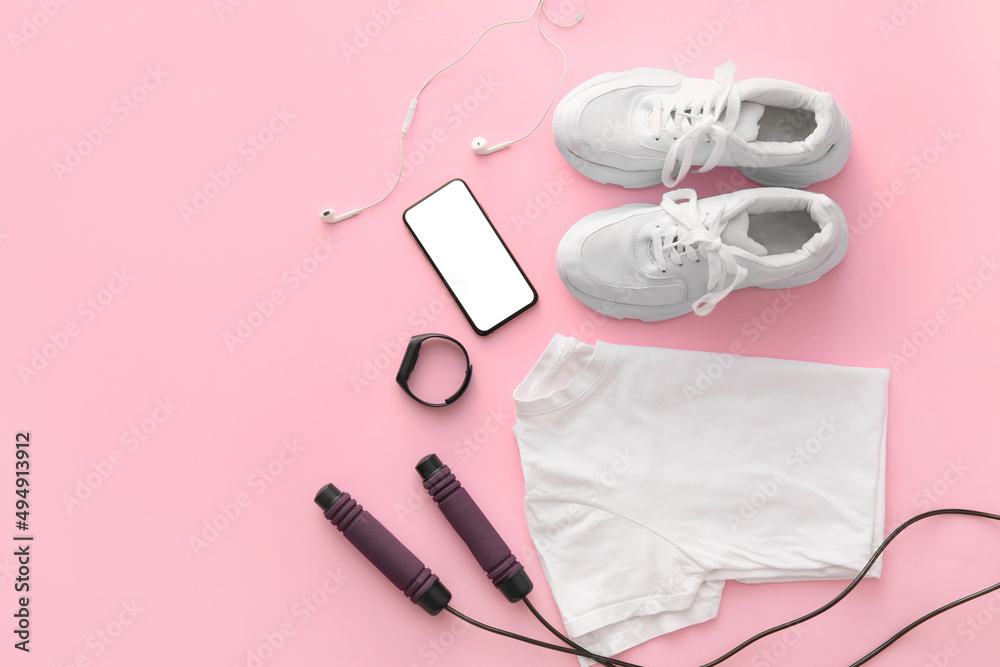 Composition with t-shirt, shoes, skipping rope and gadgets on color background