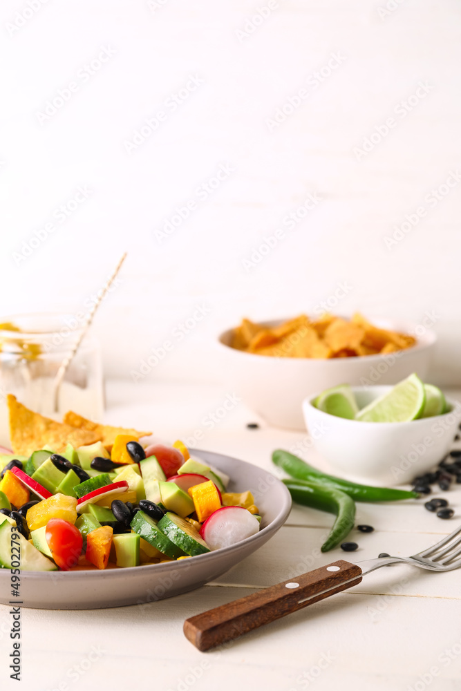 桌上有一碗美味的墨西哥沙拉，配黑豆和萝卜