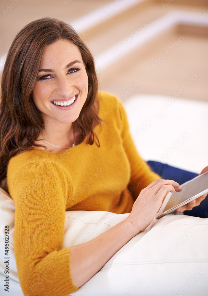 在她的数字平板电脑上读一本好书。一个漂亮的年轻女人使用数字桌子的镜头