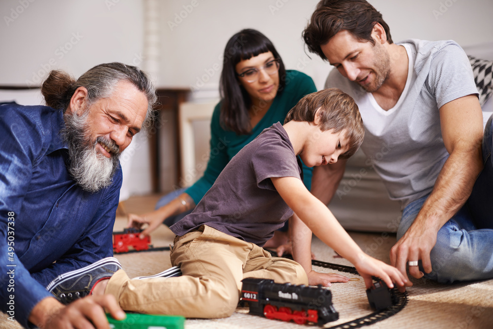 铁路上的家庭乐趣。一个小孩和家人一起玩火车的裁剪镜头