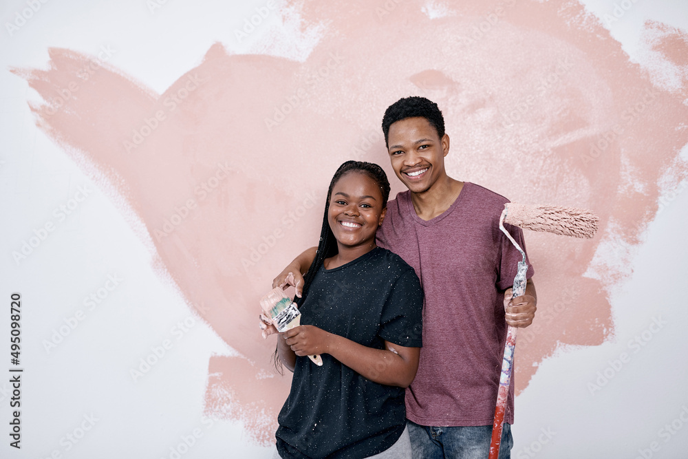Art is the ultimate expression of love. Shot of a young couple painting a wall pink.