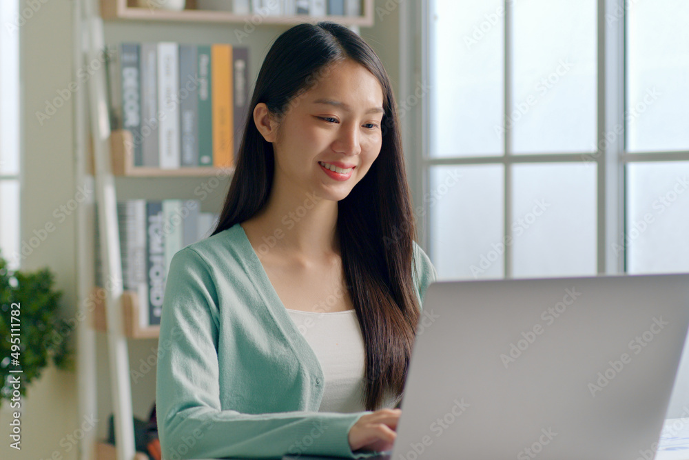 年轻的亚洲女性使用笔记本电脑在社交网络上工作、学习、聊天
