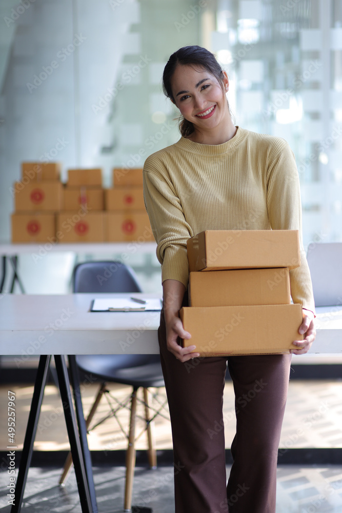 Portrait of a woman running an e-commerce startup in her home office while preparing parcels for del