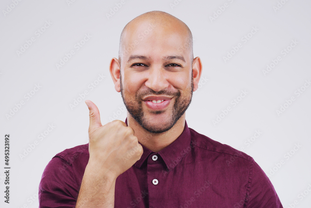 Agreement is guaranteed. Studio portrait of a handsome young man giving a thumbs up against a grey b