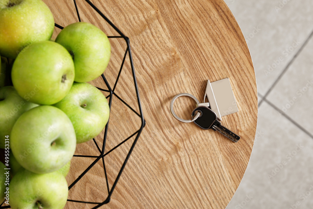 房子里的钥匙和房间木桌上放着苹果的篮子