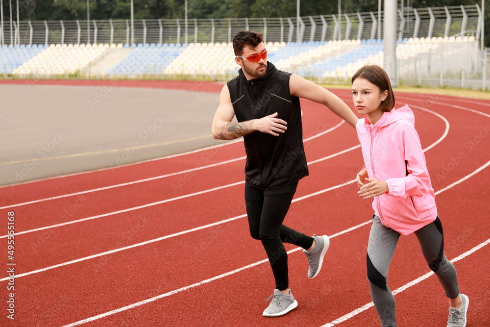 运动型年轻情侣在体育场奔跑