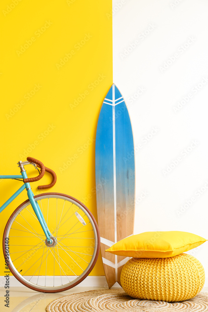 彩墙附近的冲浪板、自行车和pouf