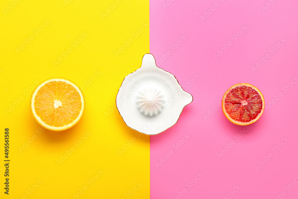 陶瓷榨汁机，在彩色背景上切割橙色和葡萄柚