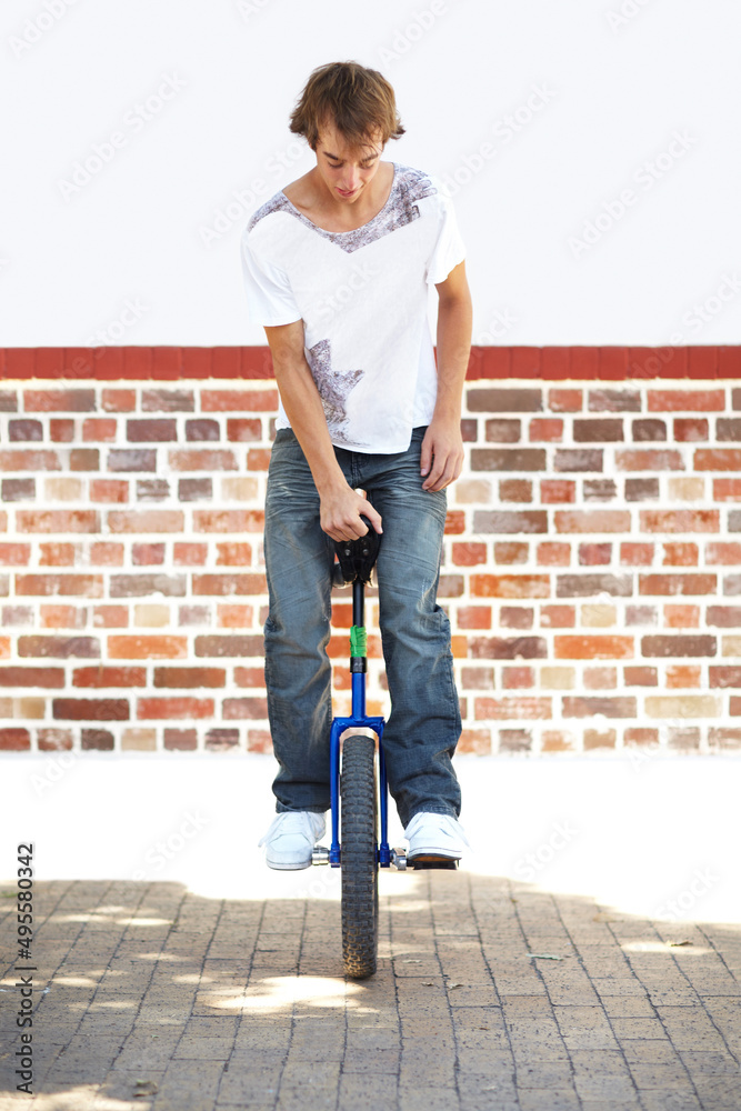他很有技巧。一个年轻人在独轮车上保持平衡的全镜头。