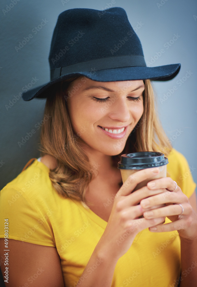 mmmm遇到ahhhh的地方。一个年轻女人在灰色背景下喝外卖咖啡的镜头。
