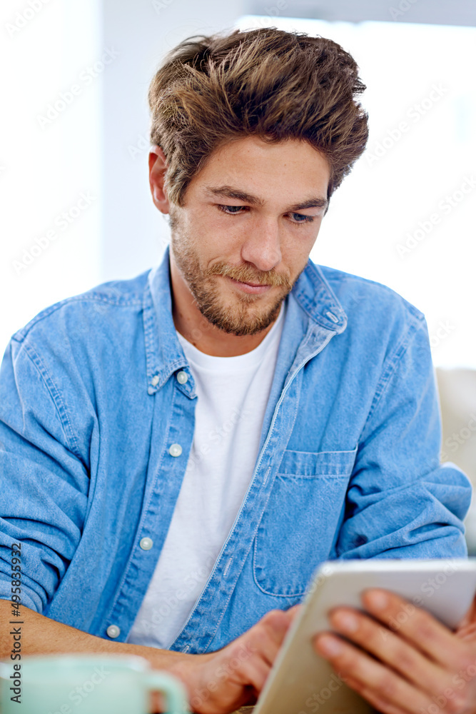 计划未来的一天。一个年轻人在数字平板电脑上工作的照片。