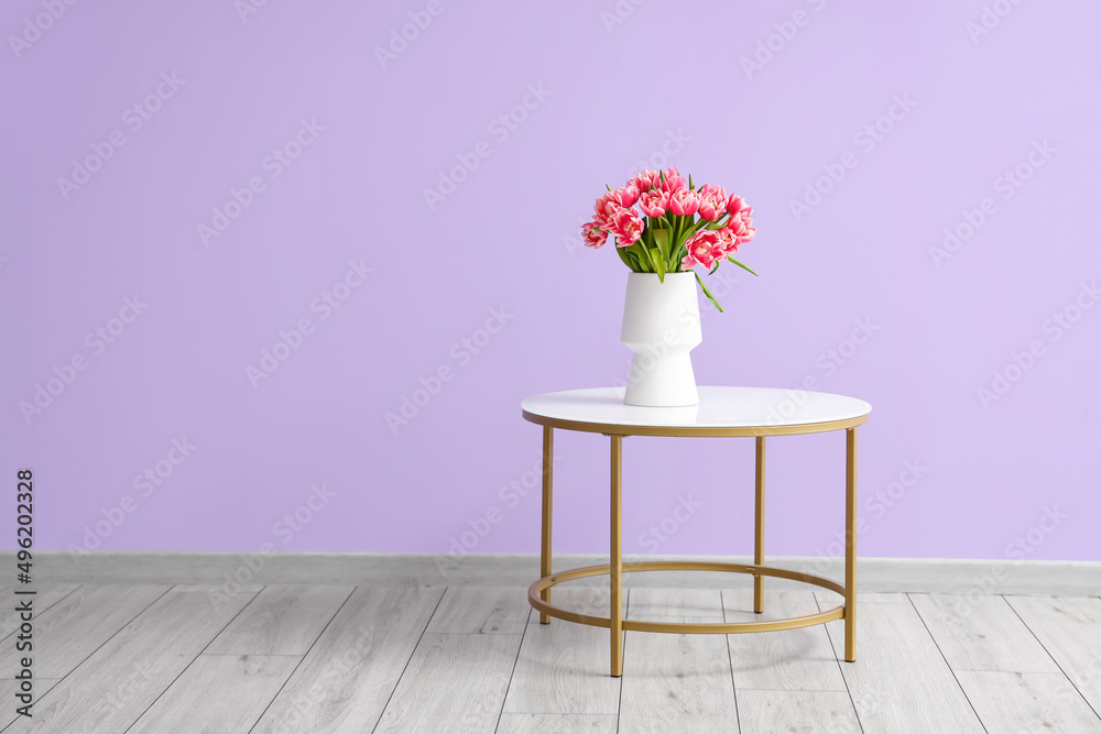 房间彩色墙附近桌子上的郁金香花瓶