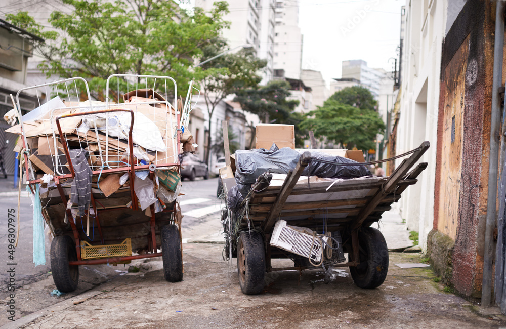 贫困无处不在。在一个贫困社区的街道上，一辆辆装满垃圾的手推车被拍到。