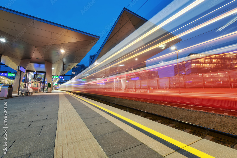 高速列车夜间在火车站上行驶。模糊的红色现代城际乘客t