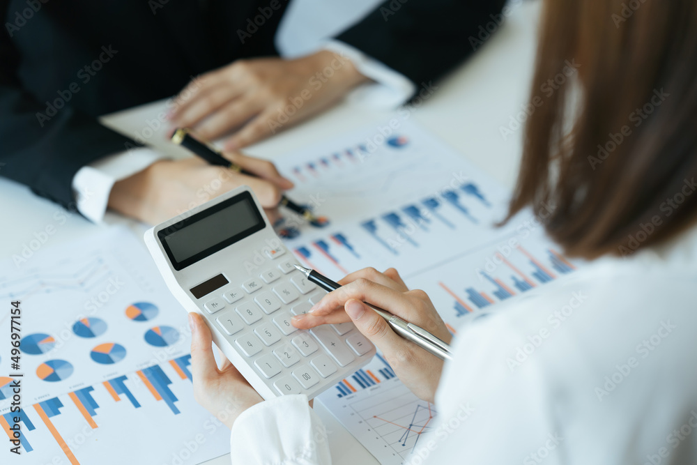 财务顾问与客户合作，在办公室的桌子上计算和分析数据。