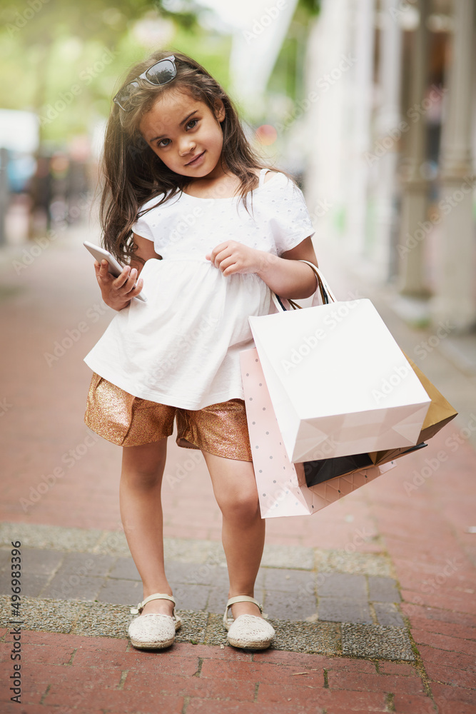 我们下一步应该在哪里购物。一个可爱的小女孩拿着购物袋外出的画像