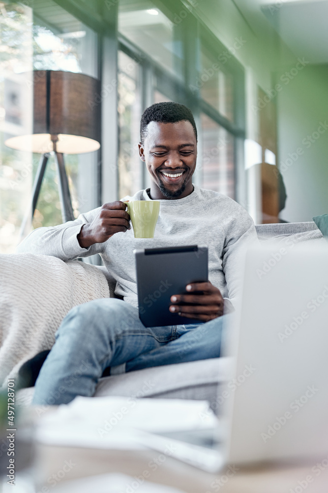 移动电影时间。一个年轻人用数字平板电脑在沙发上喝咖啡的镜头