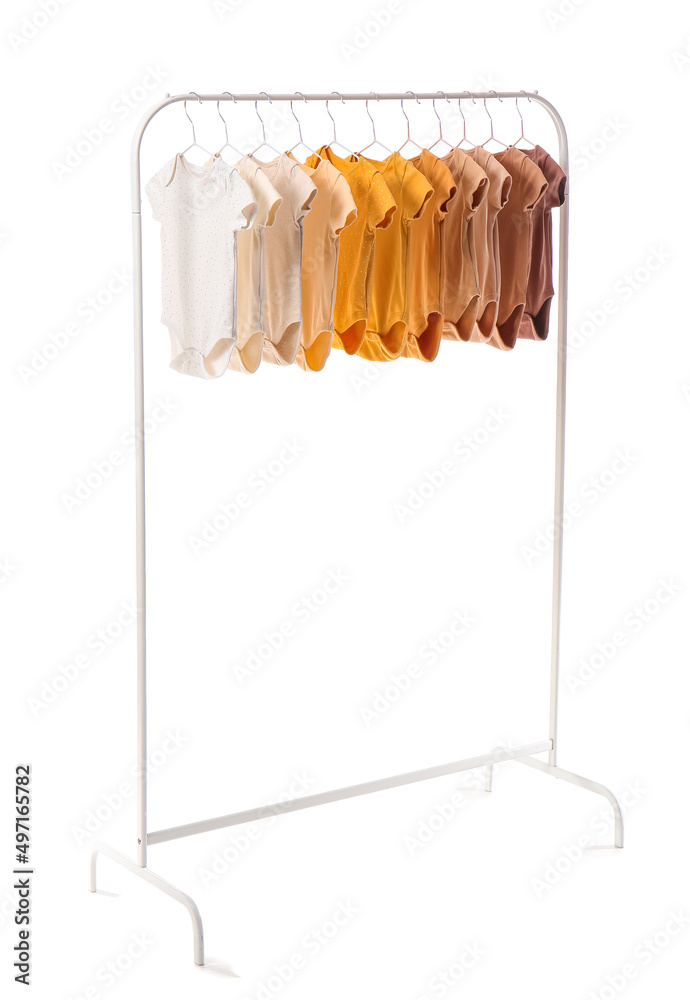 Rack with many baby bodysuits on white background