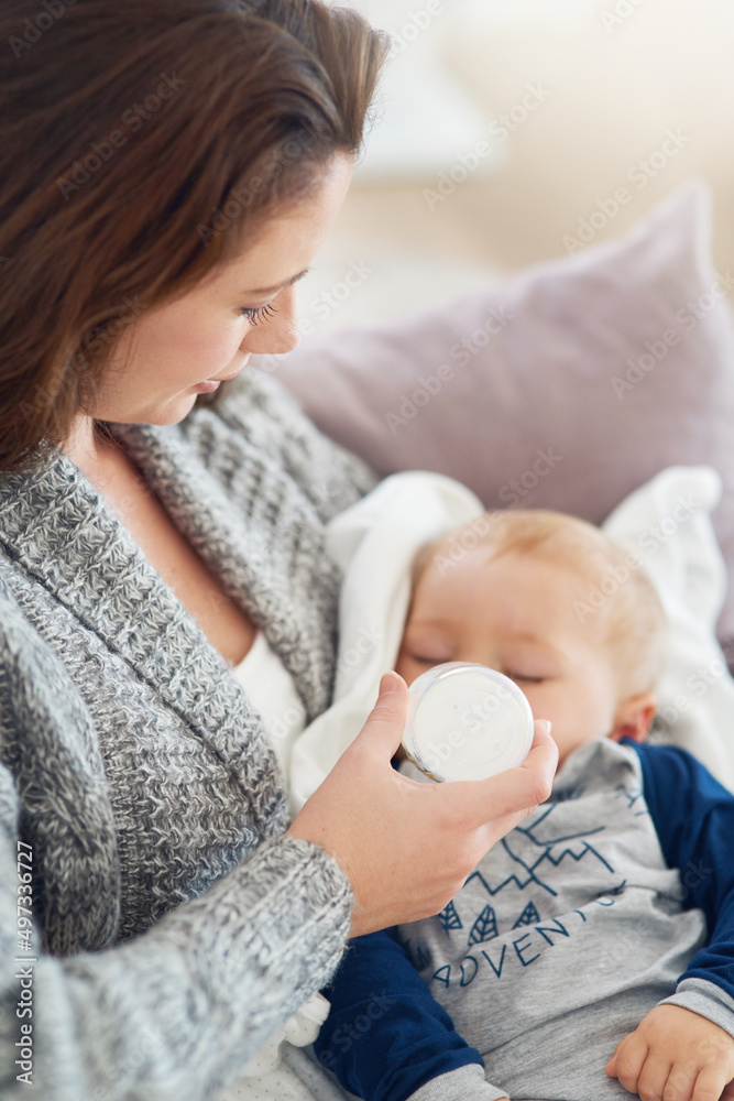 当喂食时间与小睡时间相遇时。一位母亲在家喂养男婴的裁剪镜头。