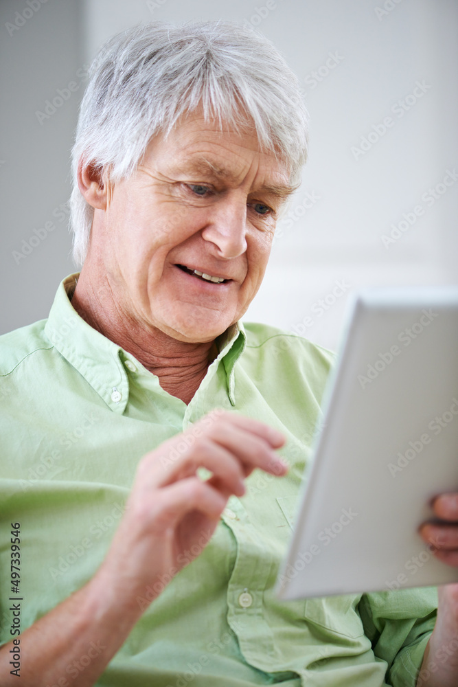 熟悉技术。一位老人坐在t上使用数字平板电脑的照片