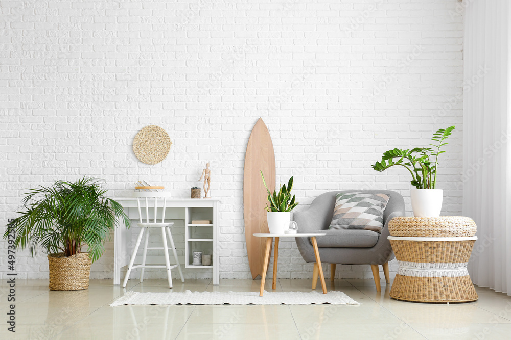 带木制冲浪板、工作场所和室内植物的轻型客厅内部