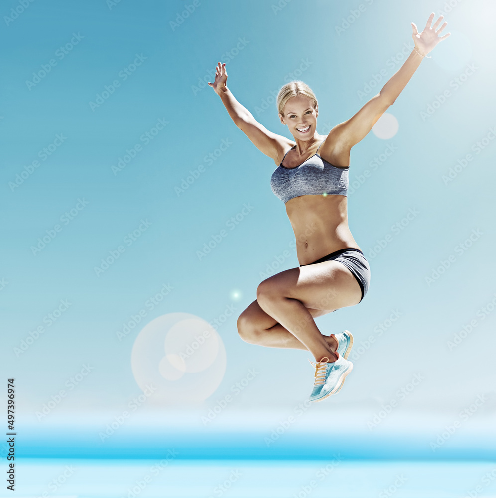 充满活力和热情。一个穿着运动装备的年轻女子在空中跳跃的镜头。
