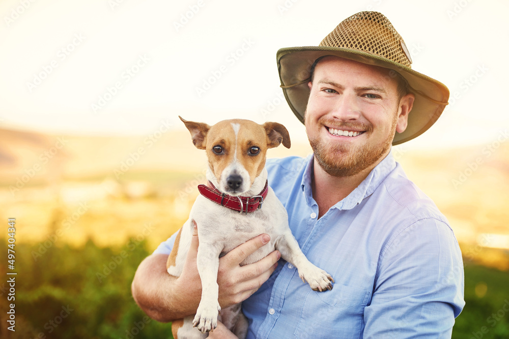 男人最好的朋友也可以是男人最好的员工。一个快乐的农民抱着他的狗的照片。