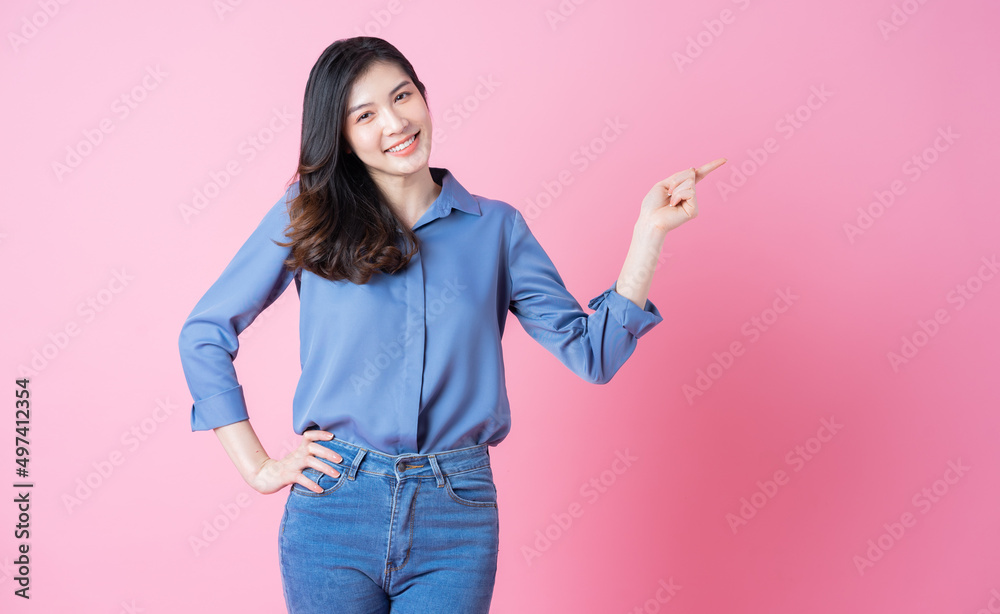 Portrait of young Asian business woman on pink background