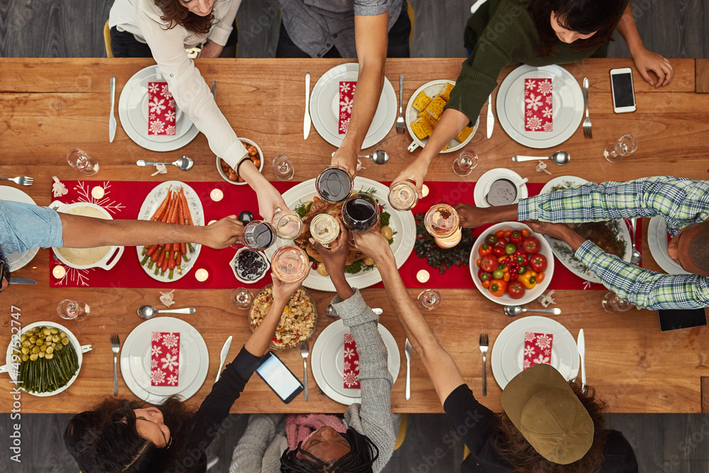 食物最好和朋友一起享用。一群人在餐桌上烤面包的裁剪镜头
