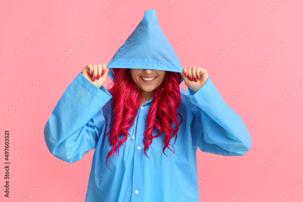 美丽的女人，明亮的头发，穿着彩色背景的雨衣