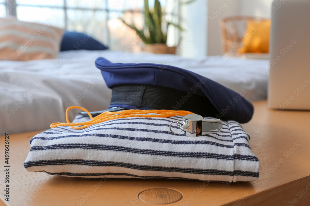 水手条纹衬衫、帽子和哨子放在卧室的长椅上