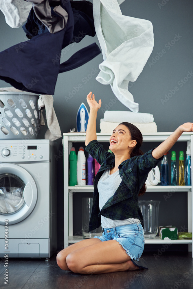 今天是洗衣服的日子。一个漂亮的年轻女人把洗好的衣服扔到空中的全长镜头。