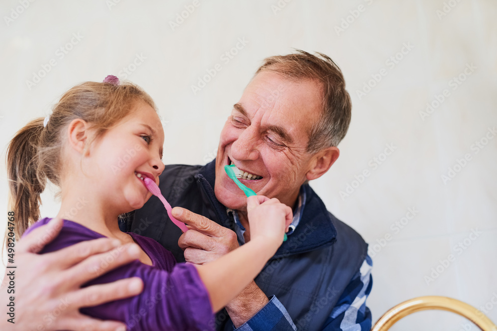 记住，每天两次，两分钟……一个父亲和他年幼的女儿刷牙的镜头。
