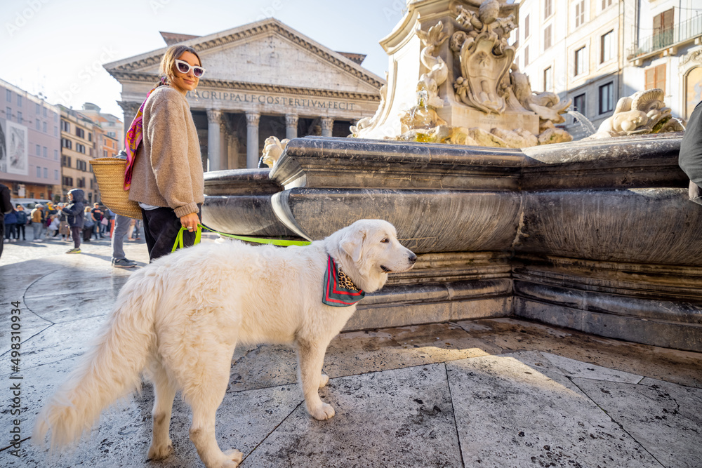 一名女子带着她的狗在罗马万神殿附近散步。一位穿着可爱的白色意大利裙的时尚高加索女子