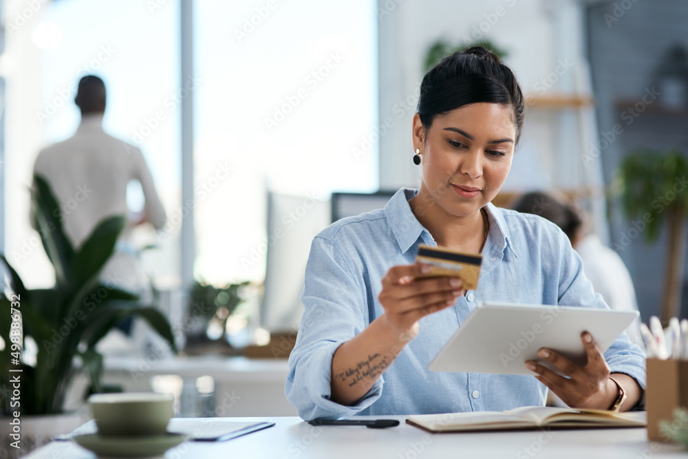 轻松完成商业支付。一位年轻女商人使用数字平板电脑和cre的照片