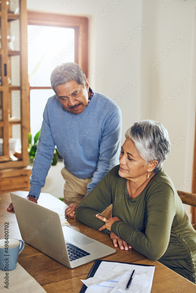 以数字方式平衡他们的账目。一对成熟的夫妇在家一起管理文书工作的照片。