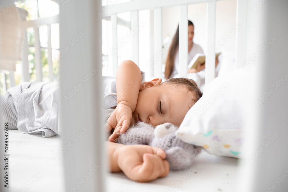可爱的婴儿和玩具睡在婴儿床上，特写