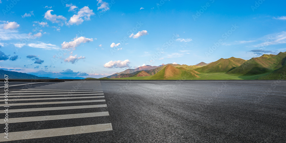 夏日蓝天下的柏油路和山体自然景观。道路和山体背景。