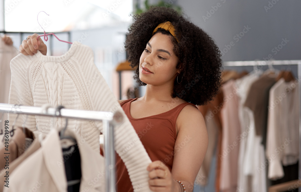 买还是不买。一名年轻女子在商店里买衣服的镜头。