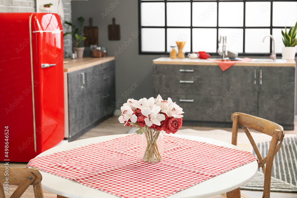 Dining table with beautiful flowers in kitchen
