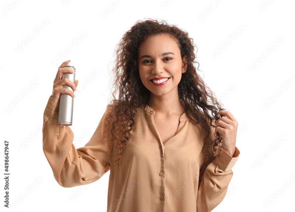 Pretty young African-American woman with hair spray on white background