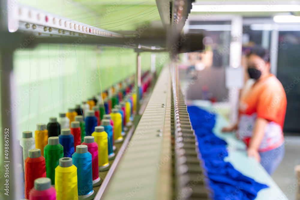 工业刺绣机上多色缝纫线的特写。选择多色的焦点