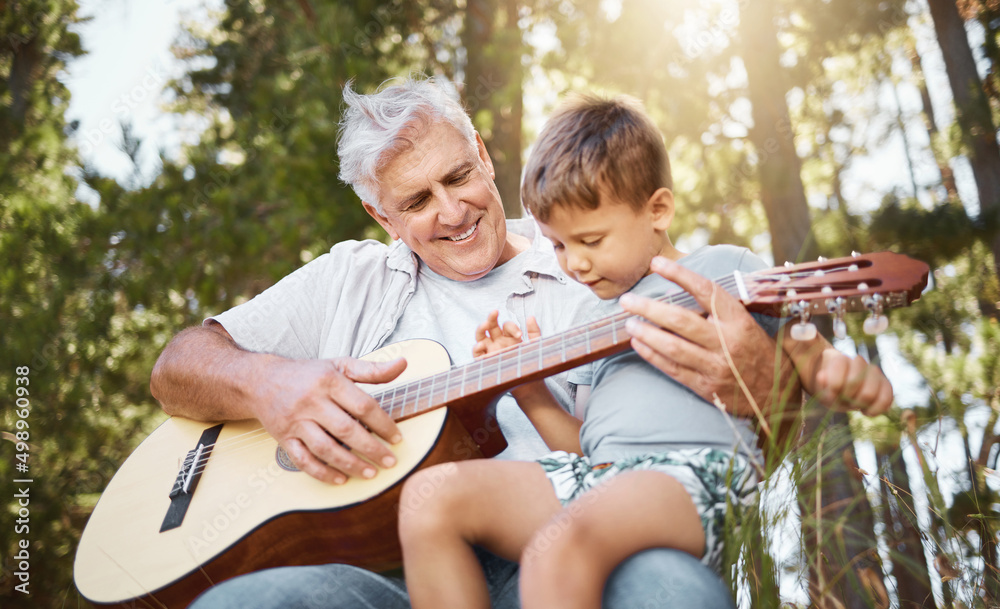 想试试看。一个英俊的成熟男人教他的孙子弹吉他的剪短镜头