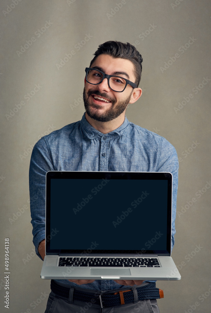 你的商业网站在这里会很好看。一个年轻人拿着笔记本电脑的工作室肖像