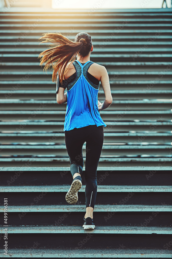 永远不要停止设定目标。年轻女性在城市锻炼的镜头。