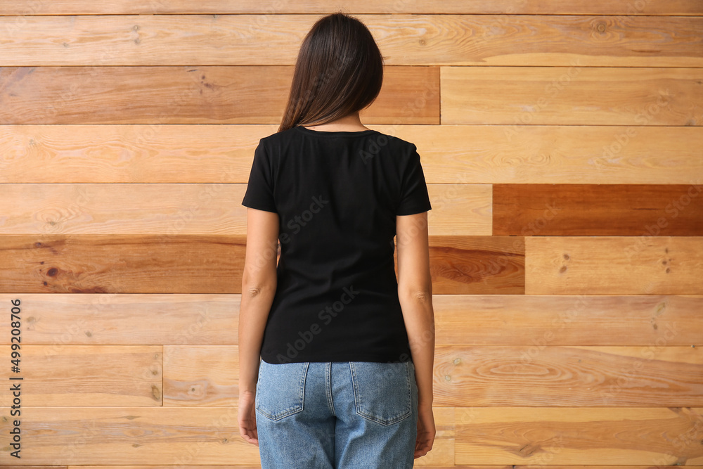 年轻女子穿着木质背景的空白t恤，后视图
