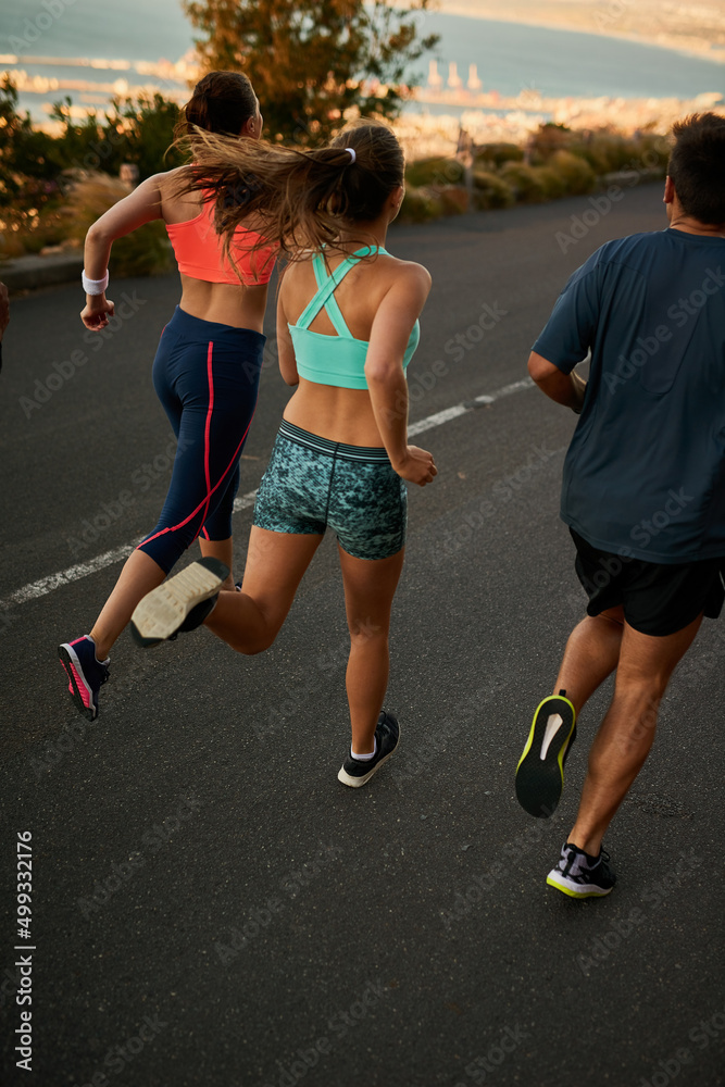 聚在一起流汗。一个健身小组在乡村公路上跑步的镜头。