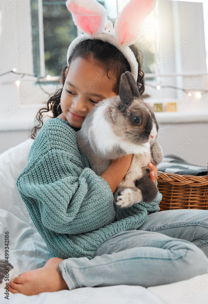 你太可爱了。一个可爱的小女孩在家里和她的宠物兔子亲密相处的照片。